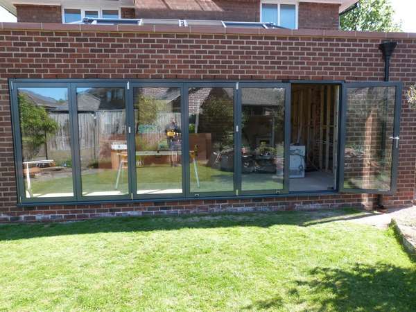 Mr B. Bebington wirral. Installation of 6200mm wide Centor C1 marine finish Alumnium Bi folding door in Ral 7016. The Bi folding doors our triple glazed with 44mm sealed units . The units have an overall U value .6.